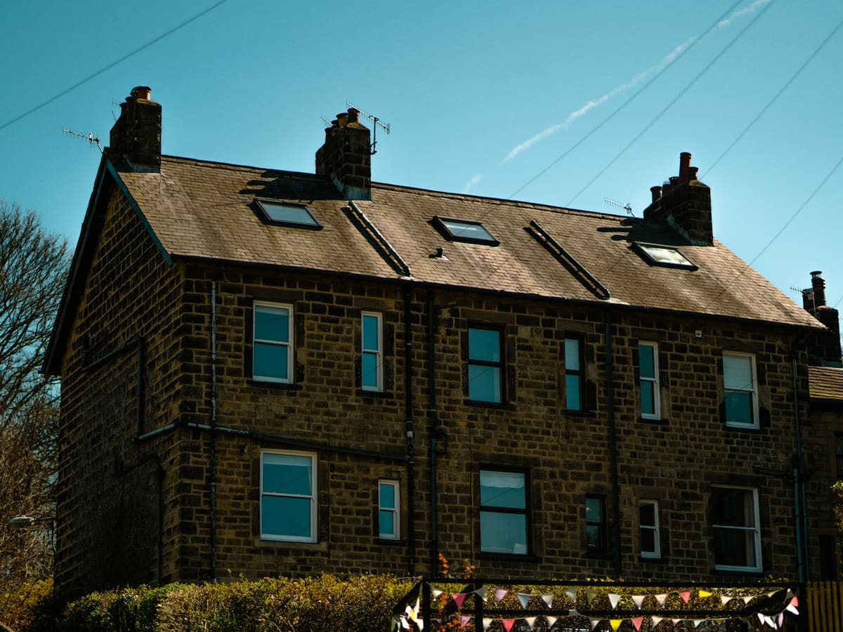 A stone-built semi-detached house with loft windows